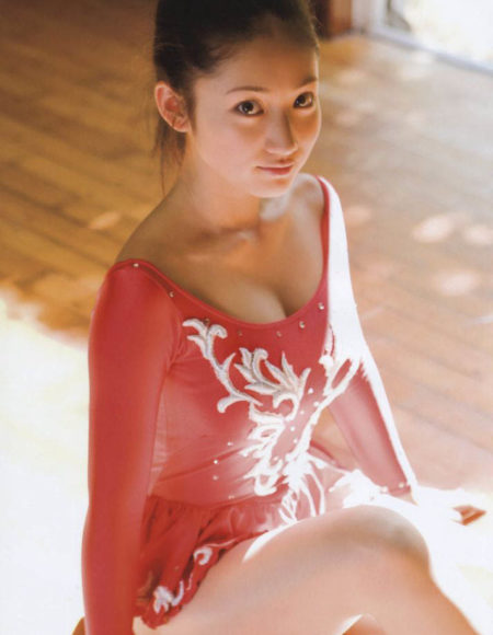 A petite Asian masseuse wearing a red ballet costume